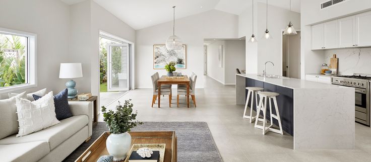 a living room filled with furniture next to a kitchen