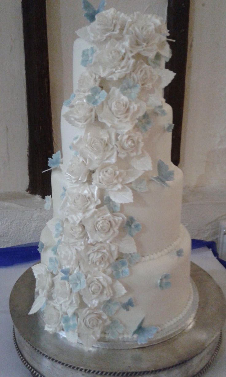 a wedding cake with white and blue flowers