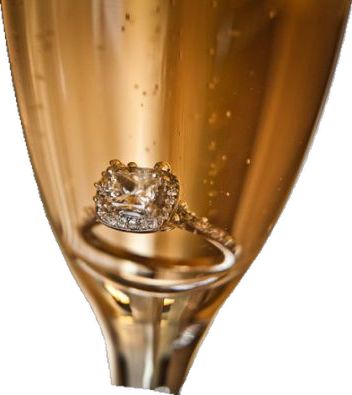 a close up of a champagne glass with a diamond ring on the top and bottom