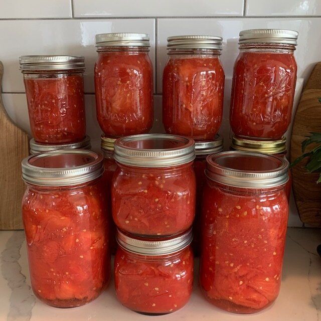 several jars filled with red sauce sitting on top of a counter