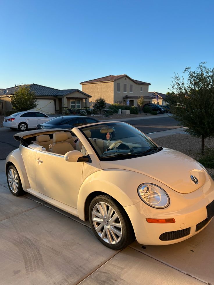 a white convertible car parked in front of a house