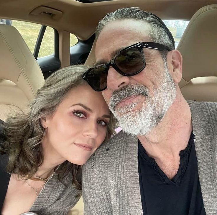 an older man and young woman are sitting in the back seat of a car together