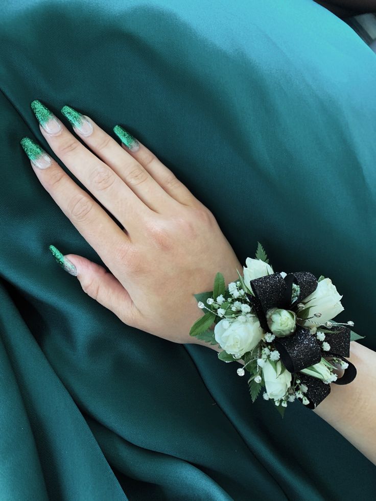 a woman's hand with green and white flowers on it