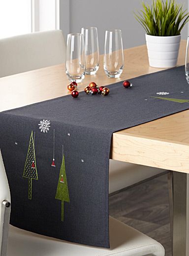 the table is set with wine glasses and place mats for christmas dinner guests to enjoy