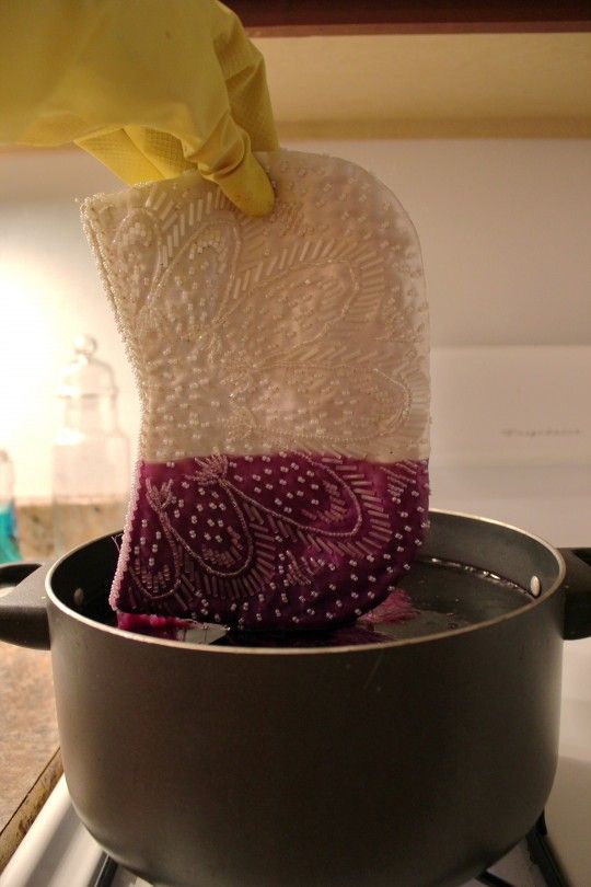 someone is using a sponge to clean the pan on top of the gas burner