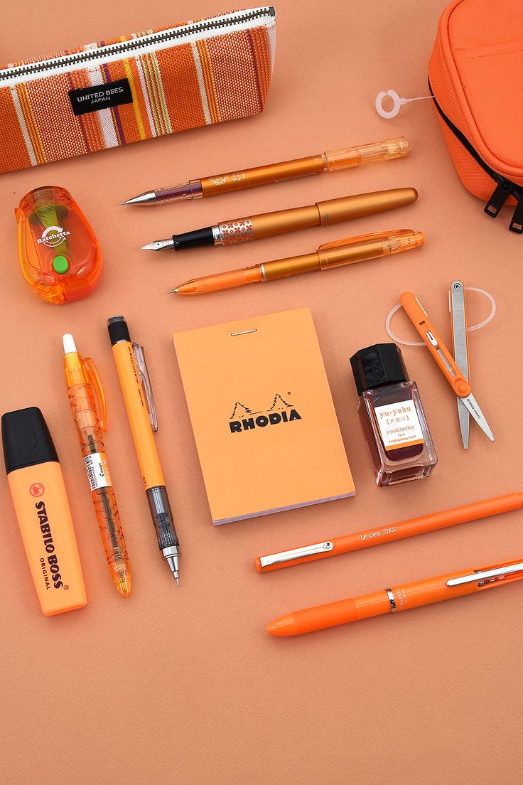 an assortment of pens, pencils, and other items laid out on a table