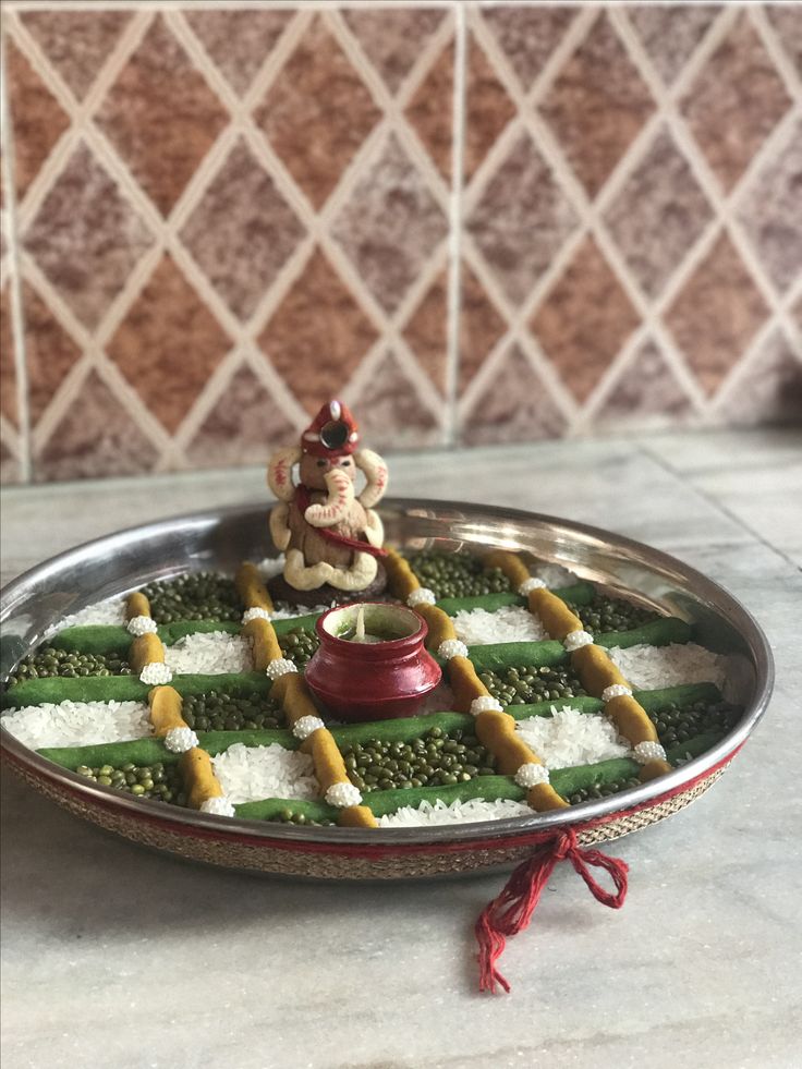 a metal tray topped with green and white food on top of a marble countertop