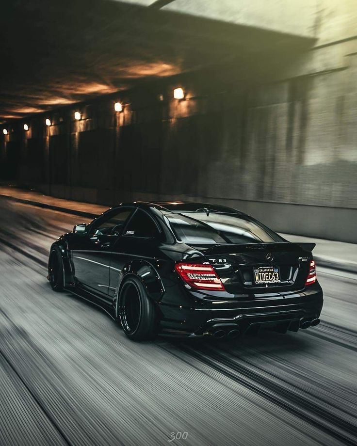 a black car driving through a tunnel