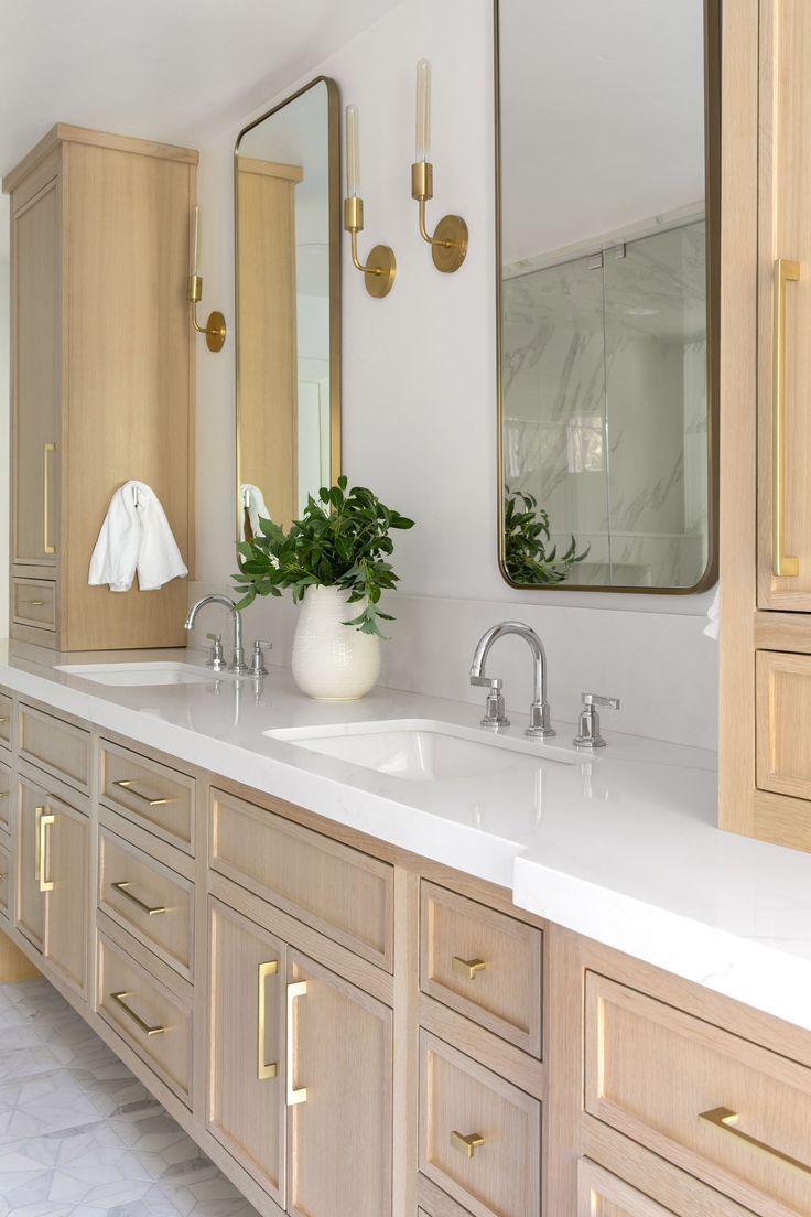 a large bathroom with two sinks and mirrors