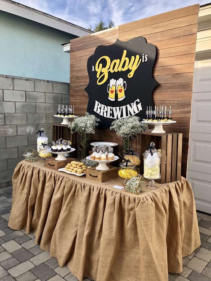 a baby is brewing themed party with food and drinks on a table in front of a sign