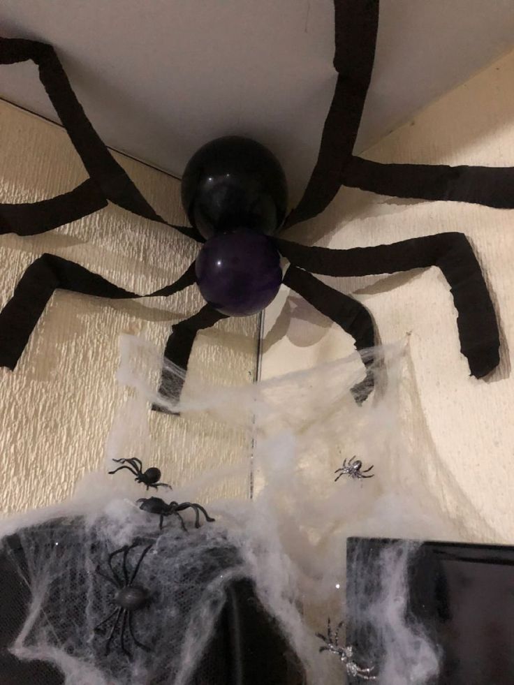 there is a fake spider hanging from the ceiling with black and white decorations on it