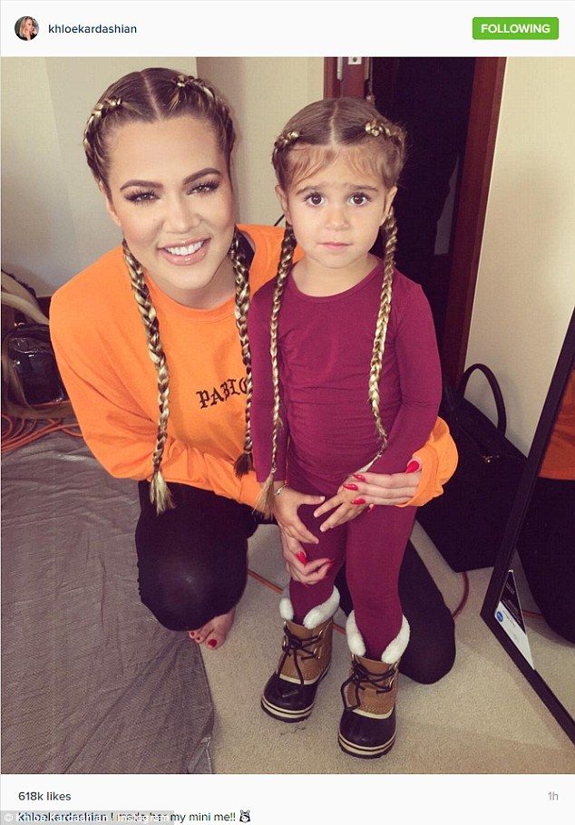 a mother and daughter standing in front of a mirror with braids on their hair