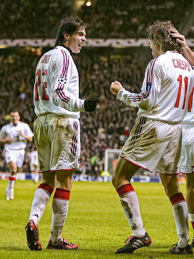 two soccer players are congratulating each other on the field in front of an audience