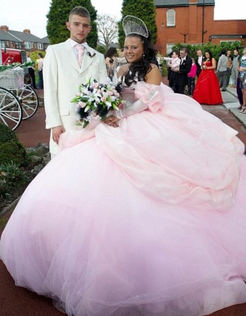 a man and woman dressed up in formal wear standing next to each other on a walkway