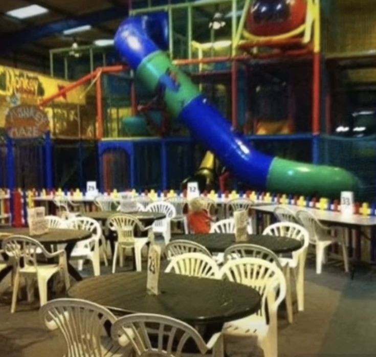 an indoor play area with tables and chairs