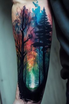 a man's arm with trees and stars in the sky on his left forearm