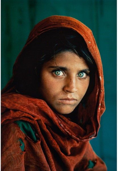 a woman with blue eyes wearing a red shawl