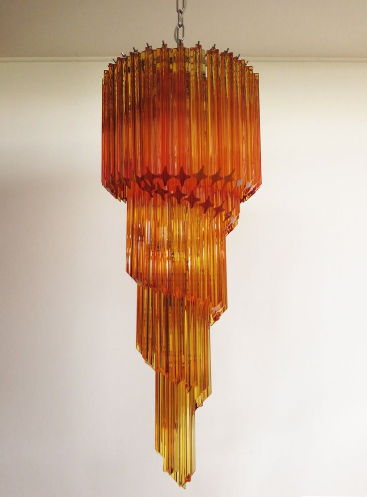 an orange chandelier hanging from a ceiling in a room with white walls and flooring