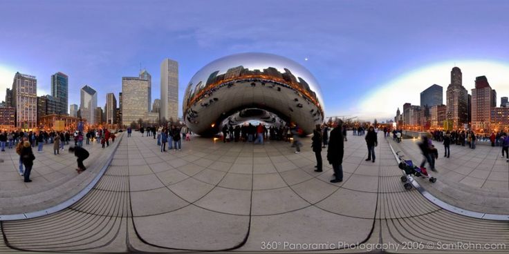 people are walking around in the city with large mirrors on it's sides and buildings behind them