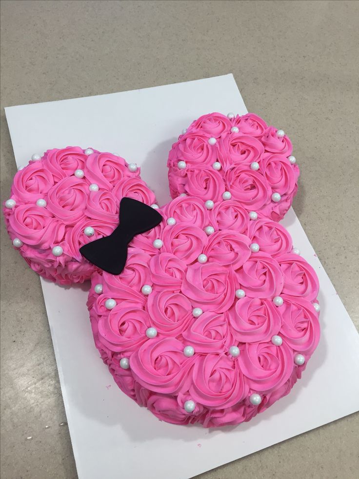 a cake shaped like mickey mouse with pink frosting