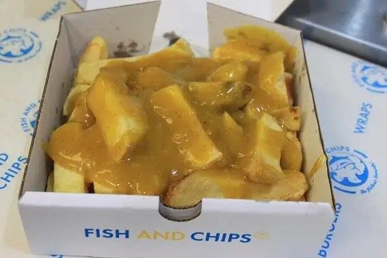 fish and chips in a box on a table