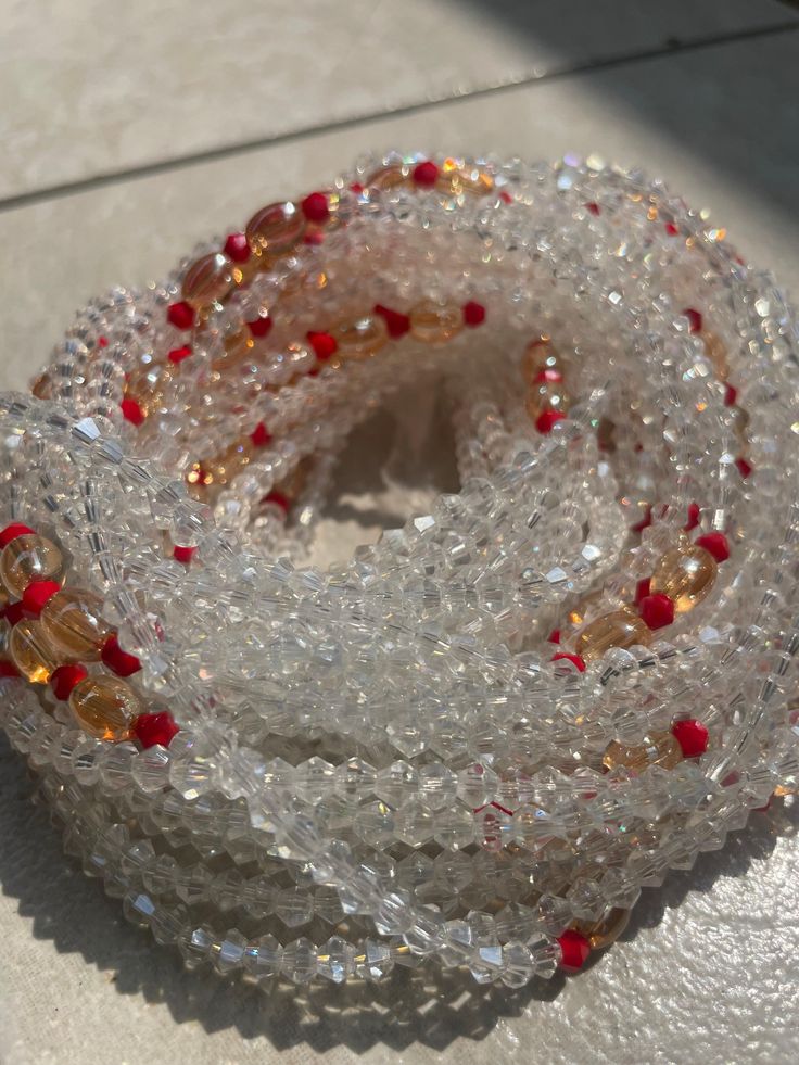 Elastic Waist Bead "Aboisso" crafted with luminous white glass crystal seed beads and adorned with subtle accents of passionate red crystal seed beads. This elastic waist bead not only epitomizes purity but also infuses a touch of fiery elegance, offering a comfortable and adjustable fit that transcends beauty and symbolism. 🌟 White Glass Crystal Seed Beads - Ethereal Radiance: Aboisso is adorned with a symphony of radiant white glass crystal seed beads, symbolizing purity and ethereal radiance Gemstone Waist Beads As Gift, Gift Gemstone Waist Beads, White Crystal Necklaces For Festive Occasions, White Crystal Necklace For Festive Occasions, Adjustable White Waist Beads With Spacer Beads, White Glass Beaded Necklaces For Gifts, Crystal Beaded Bracelets With Gemstone Beads, White Beaded Necklace With Faceted Beads For Festive Occasions, Party White Beaded Necklaces With Colorful Beads