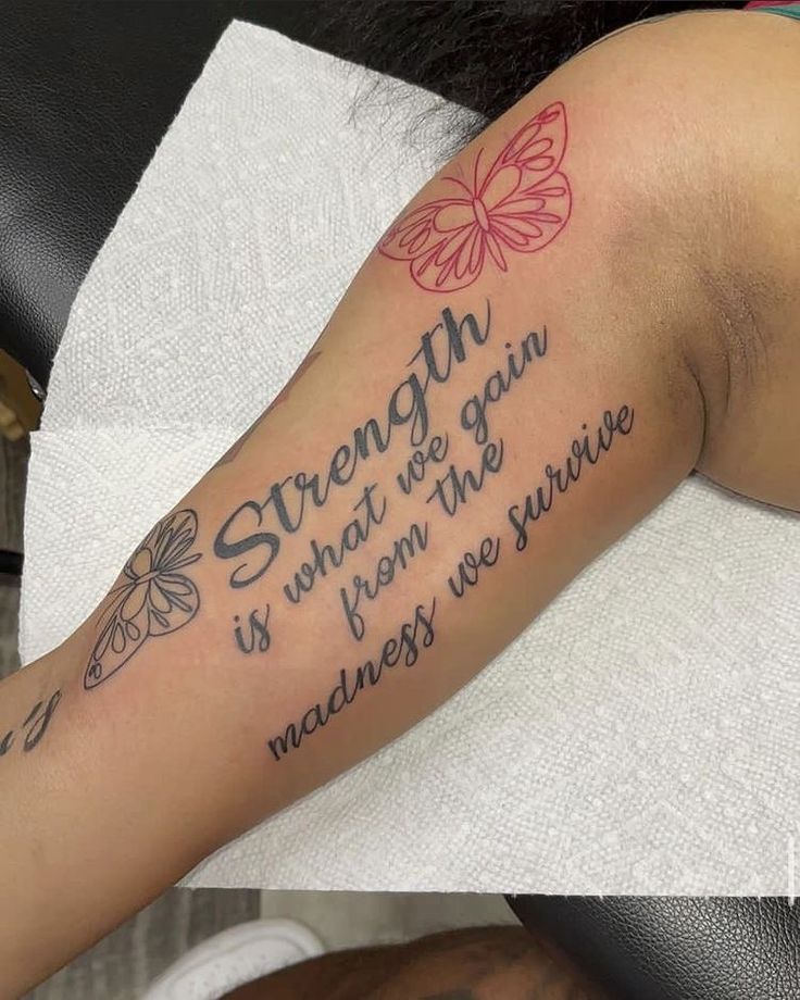 a woman with a tattoo on her arm saying strength is what we gain