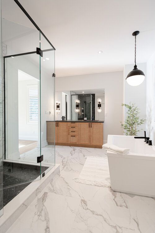 a bathroom with marble flooring and white walls, along with a large bathtub