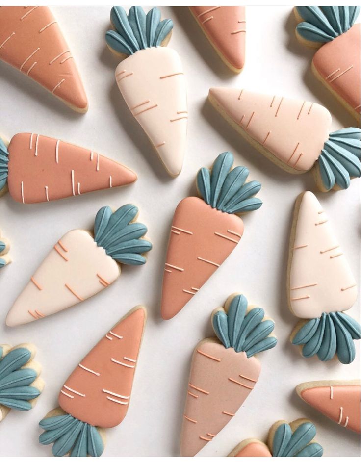 decorated cookies in the shape of carrots and radishes on a white surface