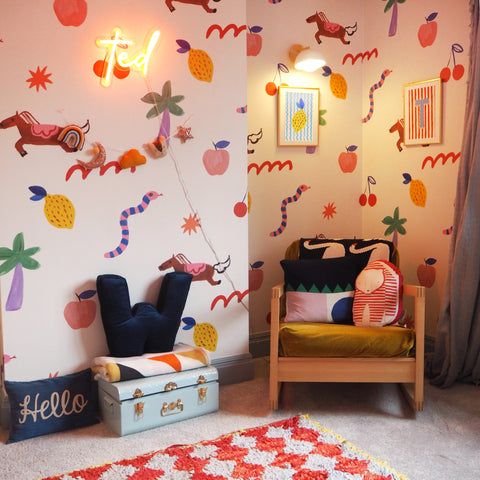 a child's room decorated with colorful wallpaper