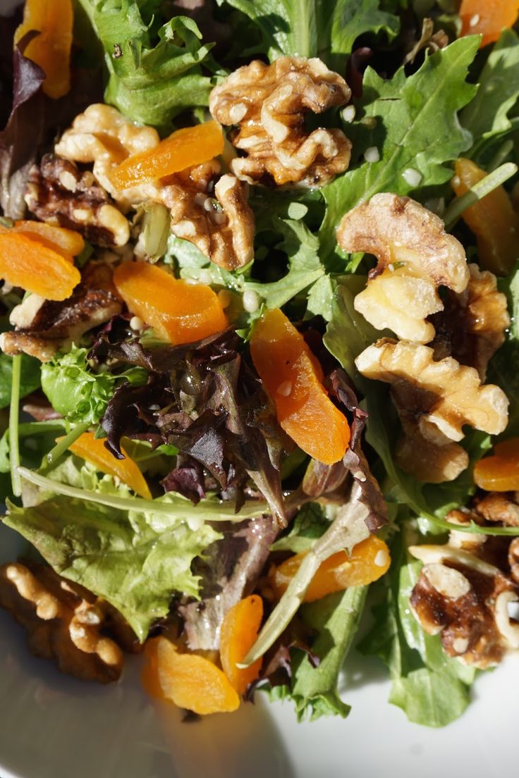 a salad with walnuts, oranges and lettuce