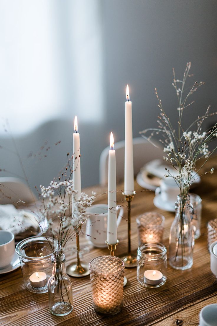 a wooden table topped with candles and dishes