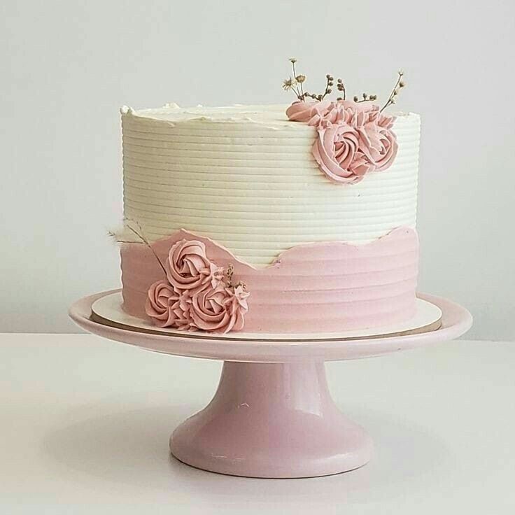 a white and pink cake with flowers on top