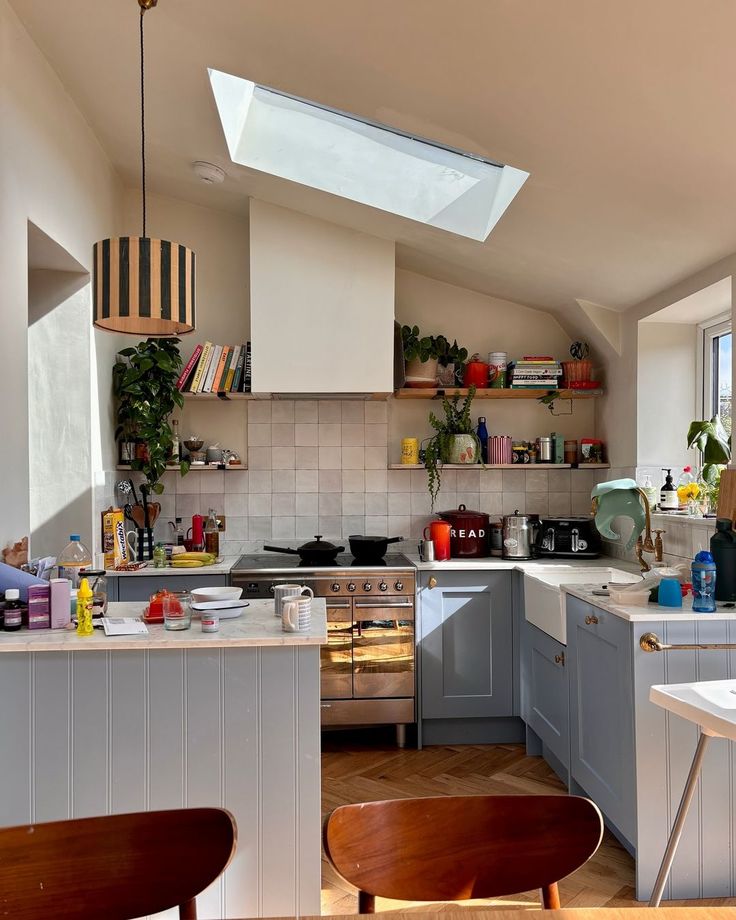 a kitchen filled with lots of counter top space and wooden chairs in front of it