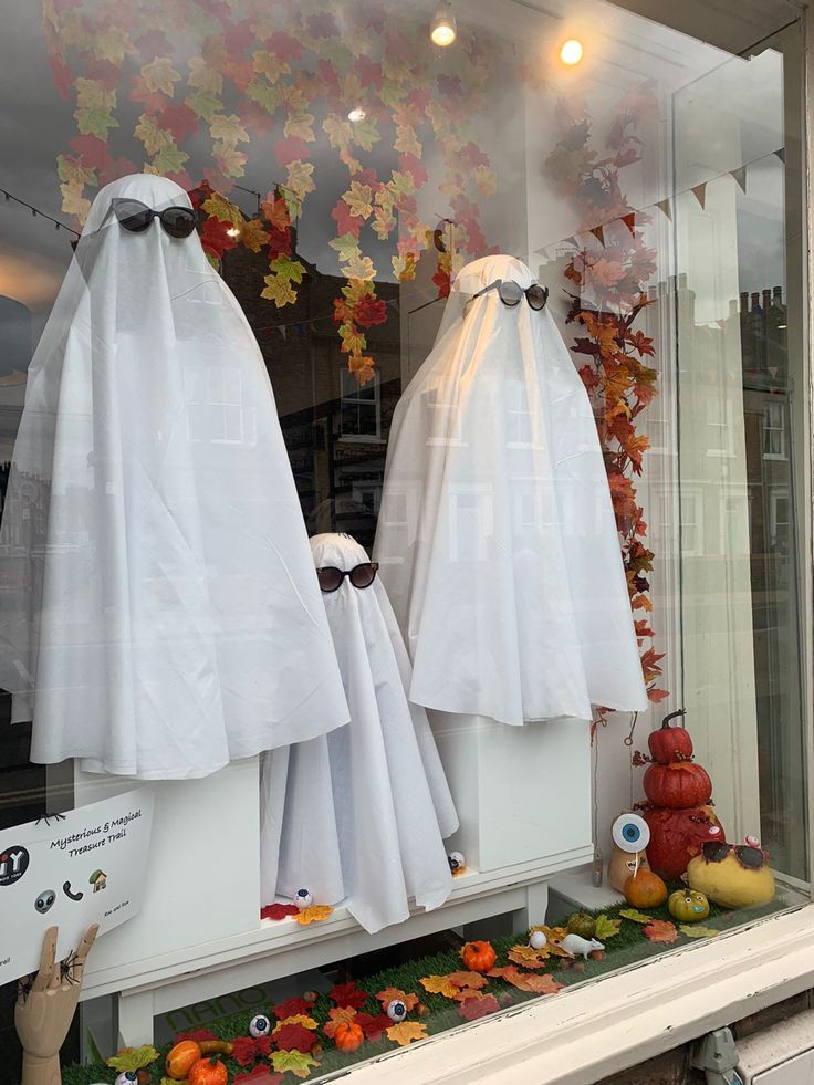 two white ghost costumes in a window display