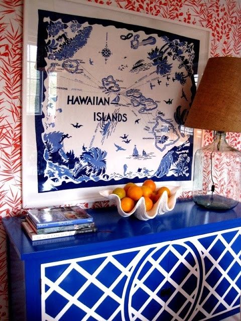 a blue and white cabinet with a bowl of oranges on it next to a lamp