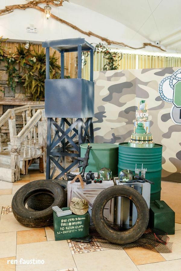 there are many tires and other items on the floor in front of a camouflage wall