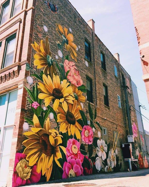 a large mural on the side of a building with flowers painted on it's sides