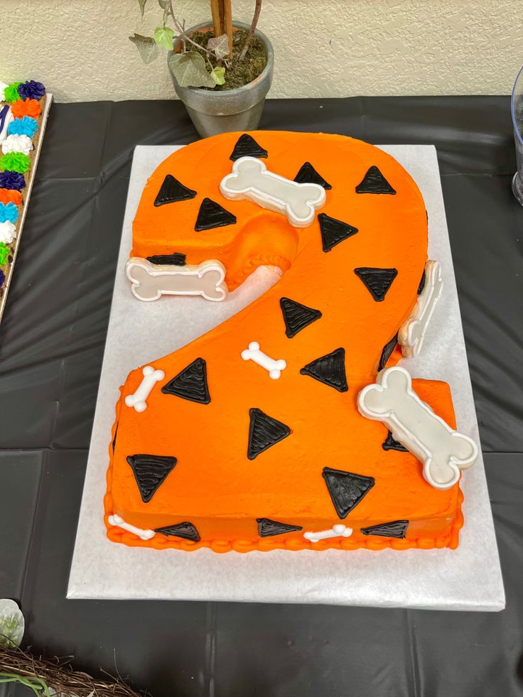 a birthday cake that is shaped to look like the number two with bones and bones on it