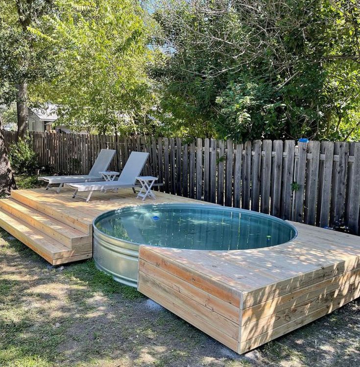 an above ground pool surrounded by wooden decking and lawn chairs in the back yard