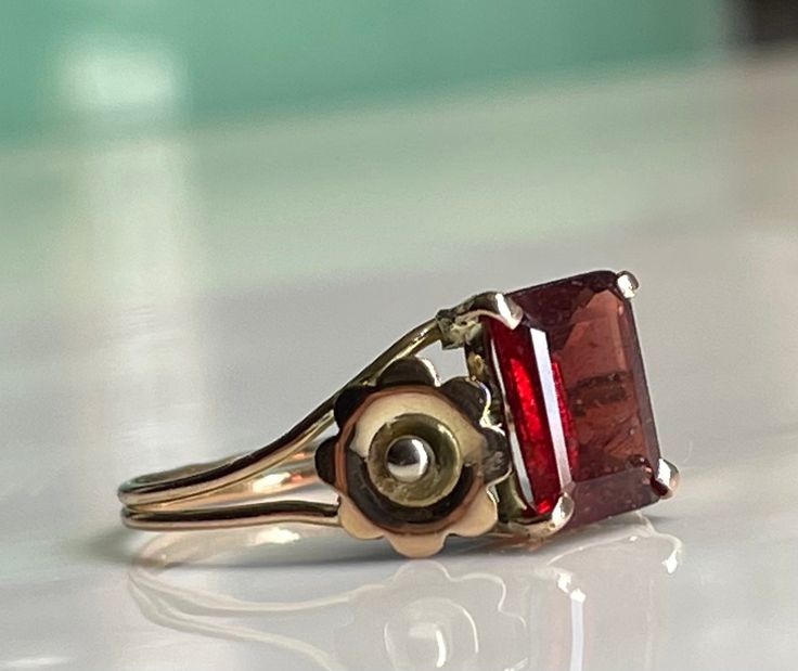 a close up of a ring with a stone in it on a white counter top