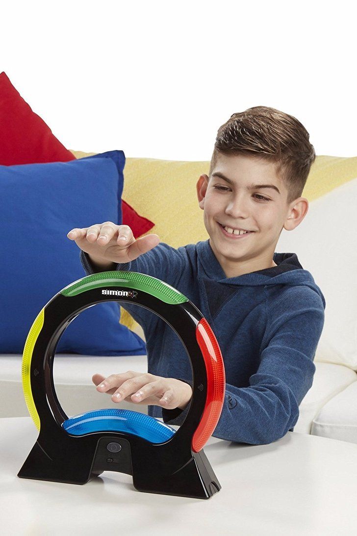 a young boy sitting at a table with three rings in front of him and smiling