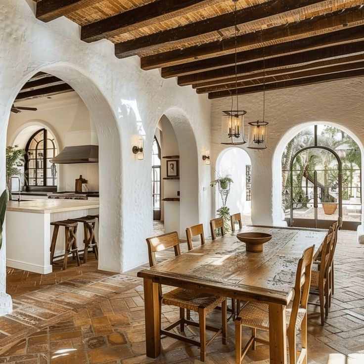 a large dining room with an archway leading to the kitchen