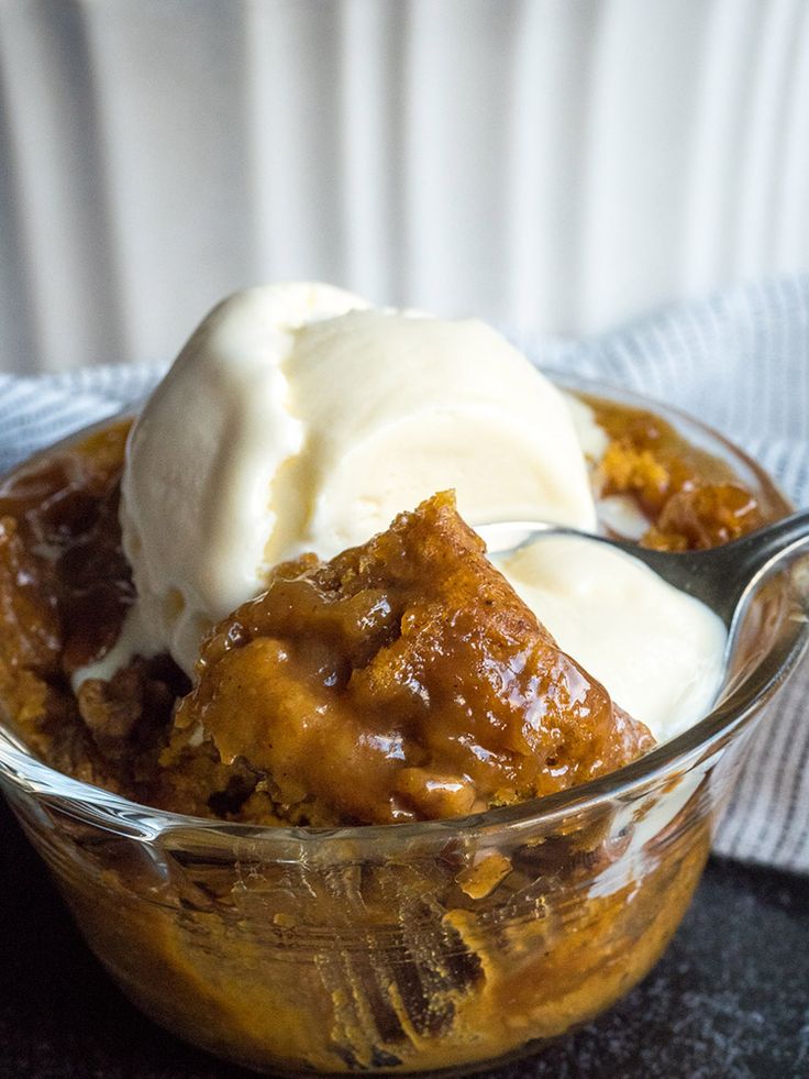 a glass bowl filled with ice cream and some kind of dessert on top of a table