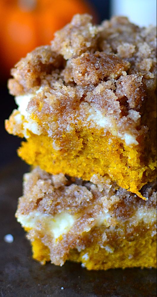 two pieces of cake sitting on top of a table next to an orange and white pumpkin