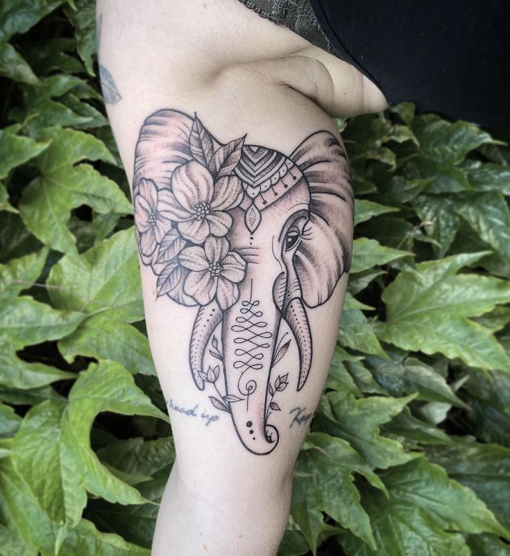 an elephant with flowers on it's back leg