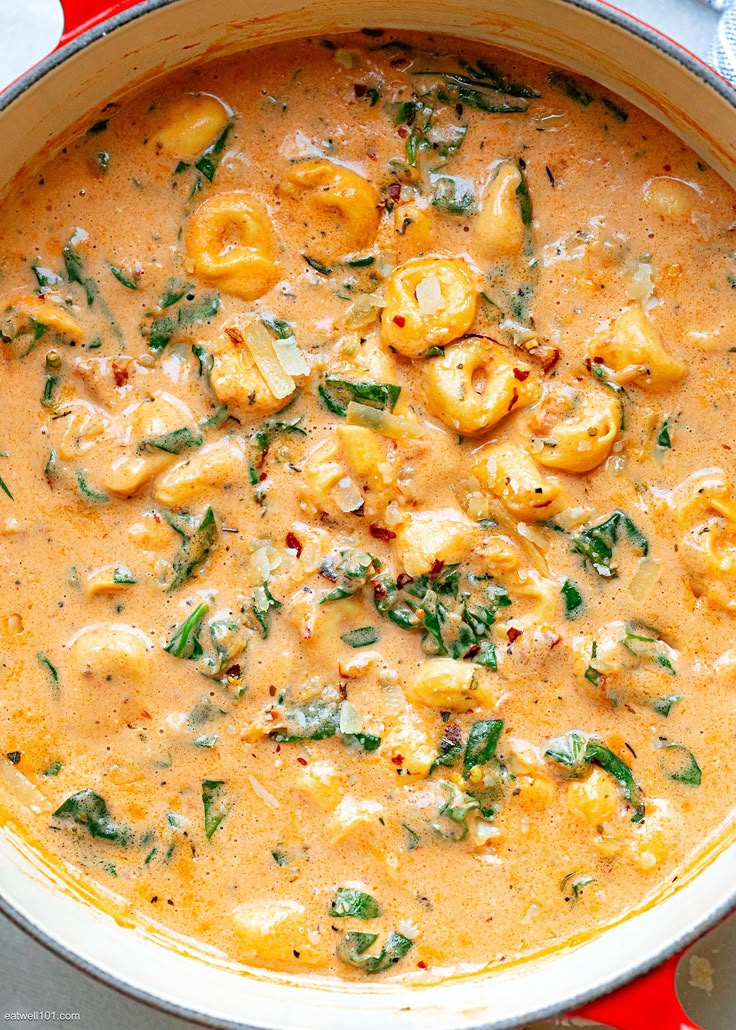 a large pot filled with pasta and spinach