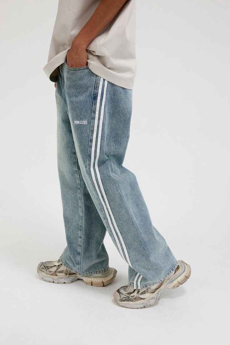 The Washed Striped Wide-Leg Pants seamlessly blend vintage style with contemporary craftsmanship. Featuring an all-over washed and distressed look, these pants are adorned with embroidered logos on each hip. The striking contrast stripes run from the back waist down the front of the legs, enhancing the body’s natural silhouette. Functional front pockets are decorated with rivets, while two back pockets provide additional utility. Crafted from premium fabric, these slightly oversized pants offer Bold Aesthetic, Oversized Pants, Striped Wide Leg Pants, Brand Sale, Accessories Branding, Rivets, Sale Design, Male Model, Oversized Fits