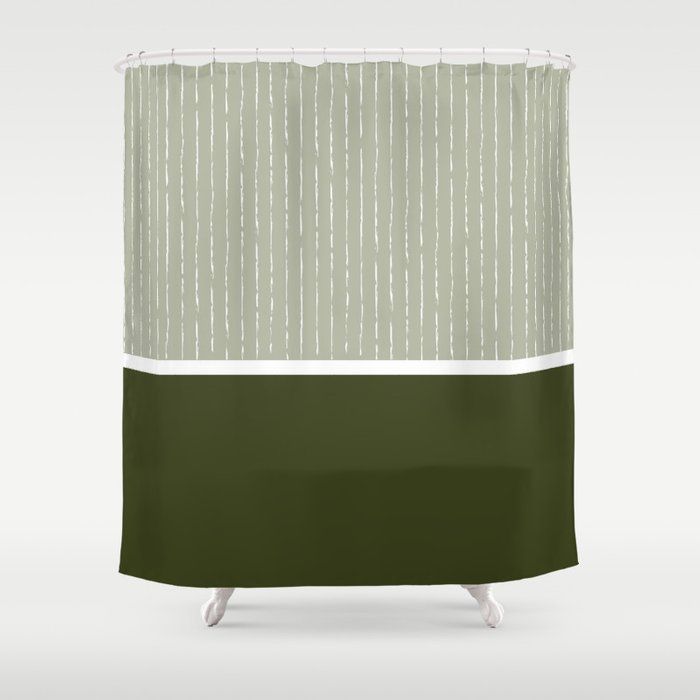 a green and white shower curtain with vertical stripes on the bottom, in front of a gray background