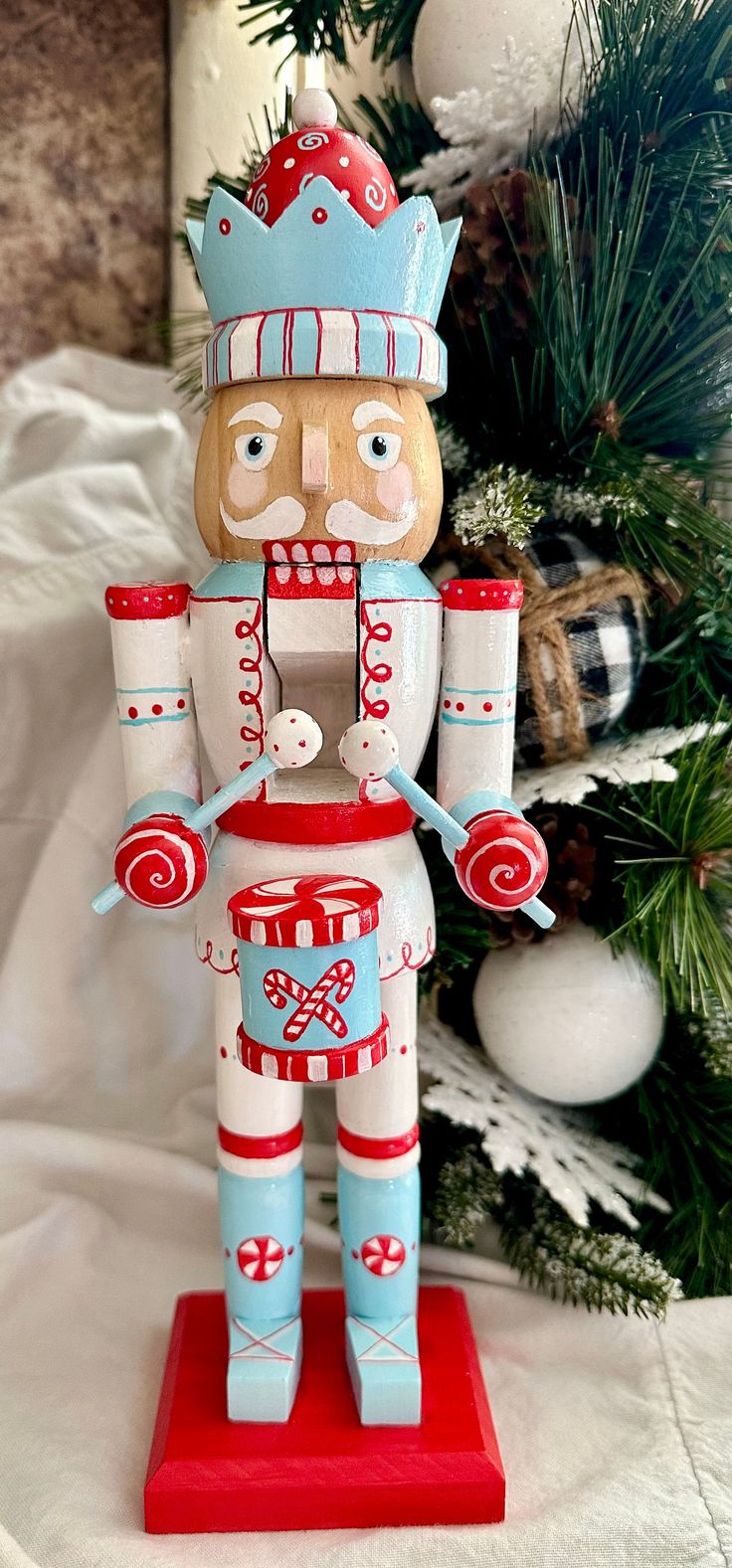 a wooden nutcracker standing next to a christmas tree